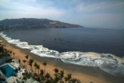 Larga capa de arena negra cubre playa de Acapulco
